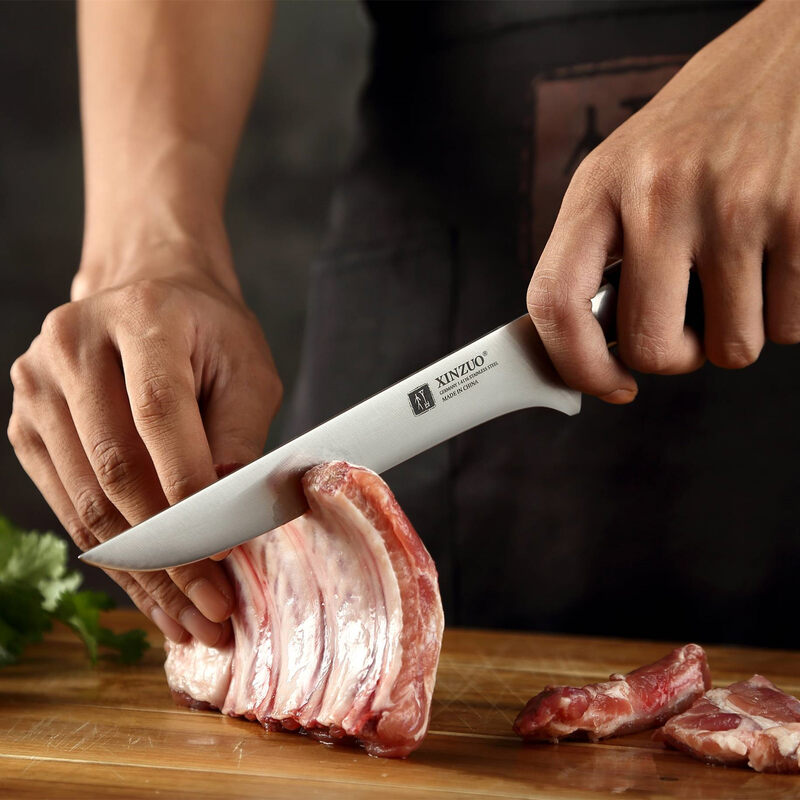 a person use XINZUO B13S Yu Boning Knife 6“ cutting meat on a cutting board