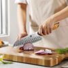 a person use XINZUO B37 Lan Santoku 7“ knife cutting a red onion