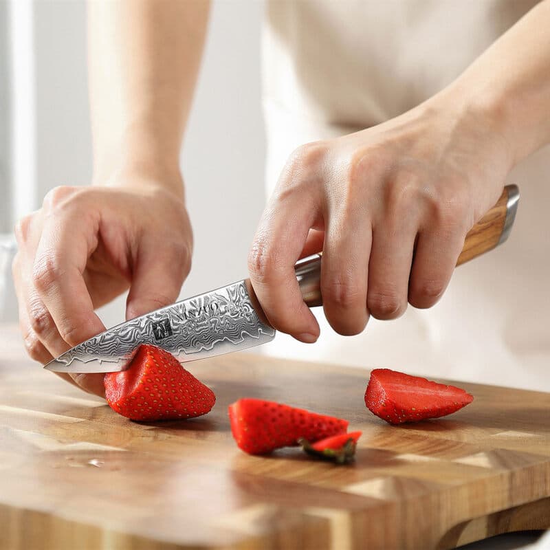 a person use XINZUO B37 Lan Paring Knife 3.5” cutting strawberries on a cutting board
