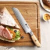a XINZUO B37S Lan Bread Knife 8.5“ next to a sandwich