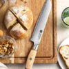 XINZUO B37S Lan Bread Knife 8.5“ on a cutting board with a bread loaf
