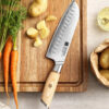 a XINZUO B37S Lan Santoku Knife 7“ on a cutting board next to vegetables