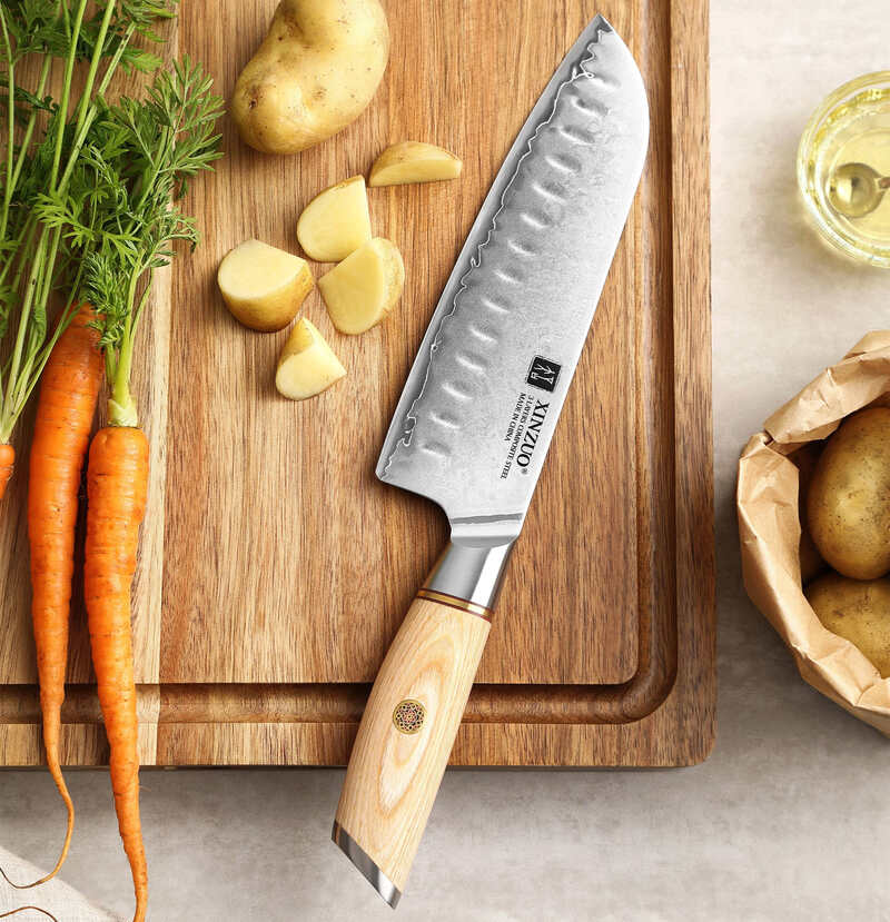 a XINZUO B37S Lan Santoku Knife 7“ on a cutting board next to vegetables